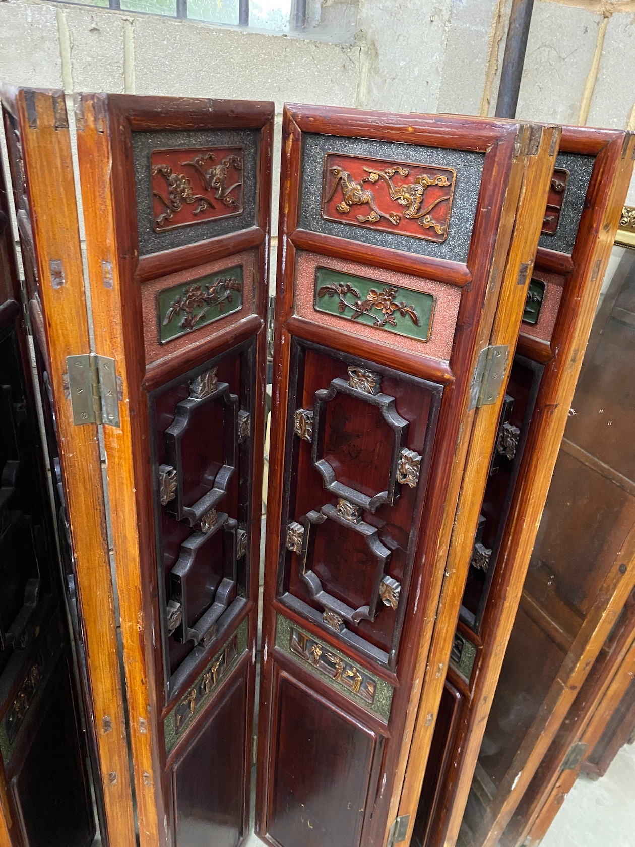 A Chinese painted carved and pierced wood seven fold screen, height 142cm